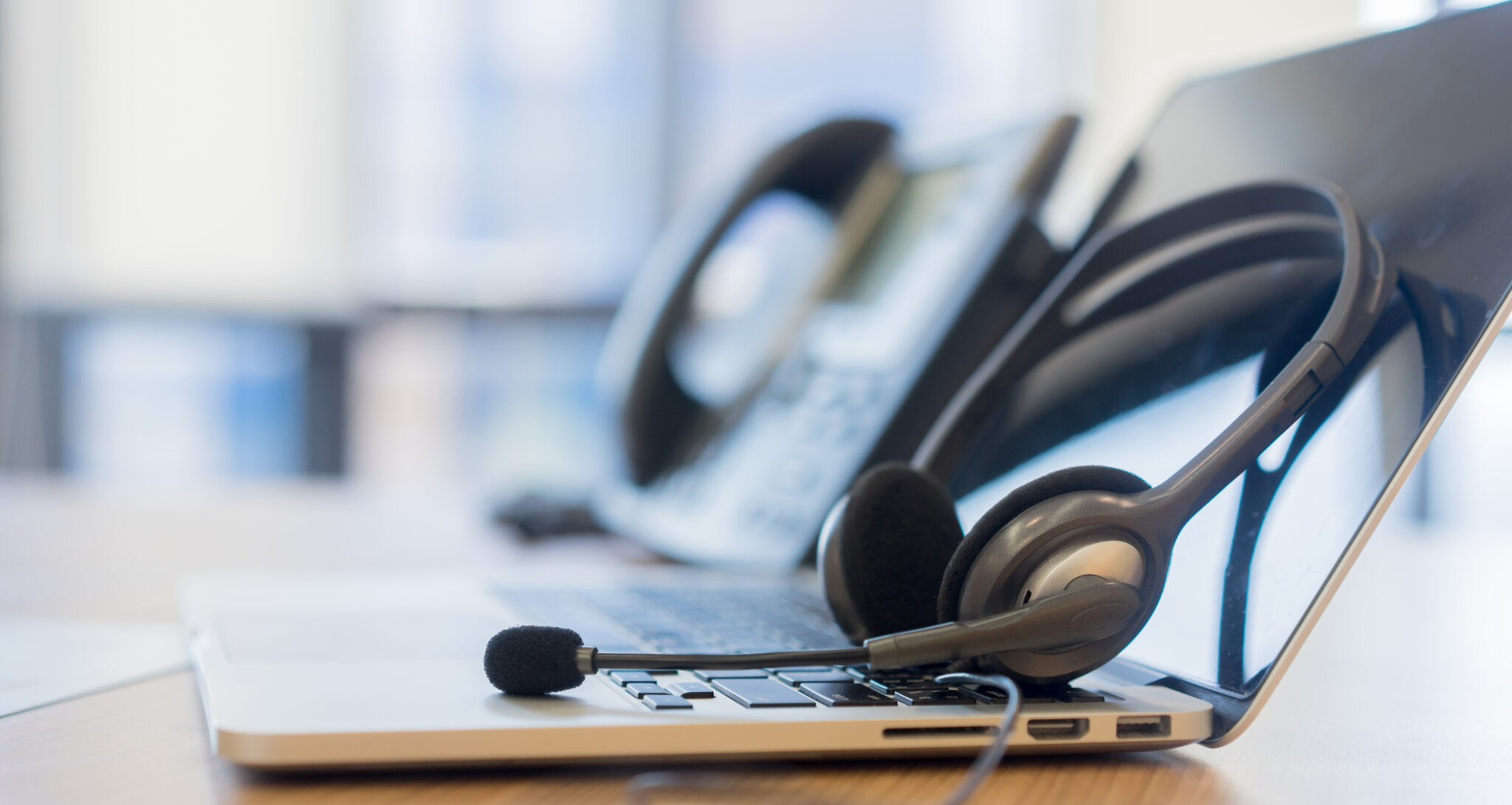 Laptop and telephone headset illustrating Telnetworks VoIP communications