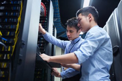 Young IT engineers inspecting data center servers.